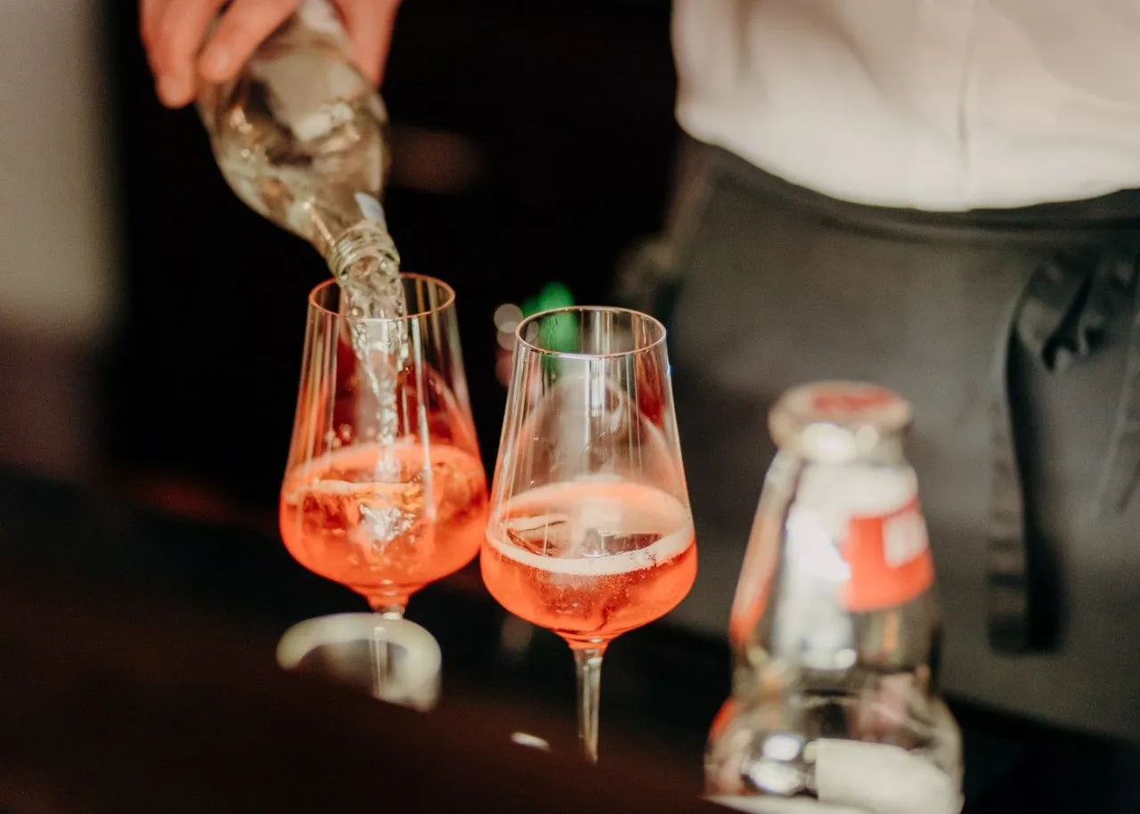 Aperitif wird in Gläser eingeschenkt