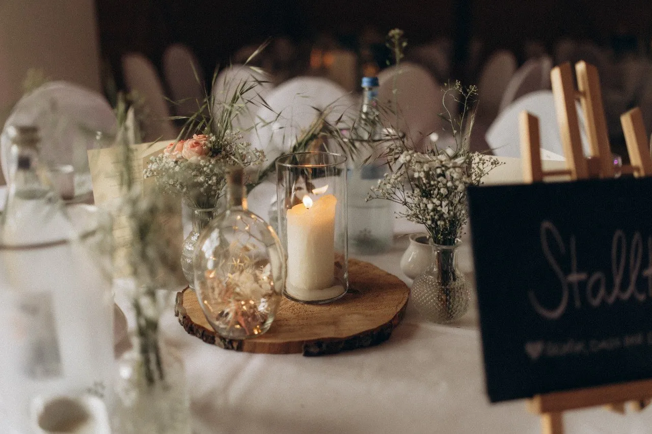 Tischdekoration mit Kerze und Blumen bei einer Hochzeit