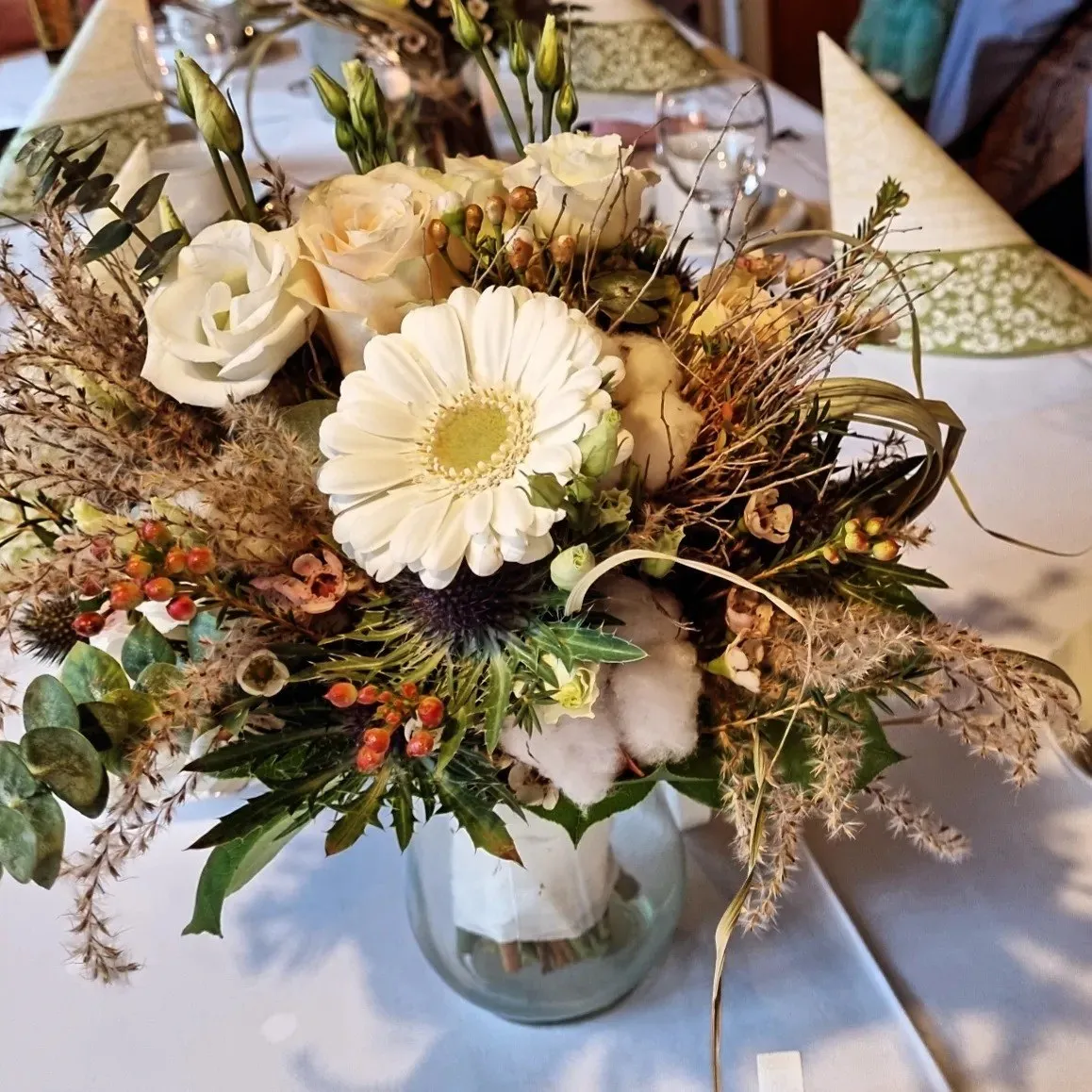 Herbstliche Tischdekoration mit weißen Rosen und Trockenblumen