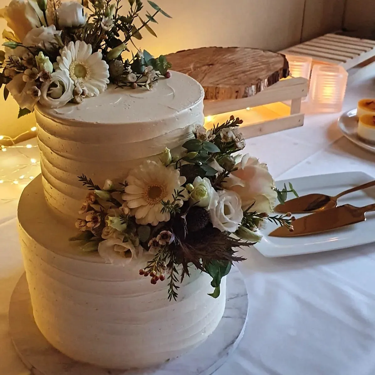 Weiße Hochzeitstorte mit floraler Dekoration und Kerzen