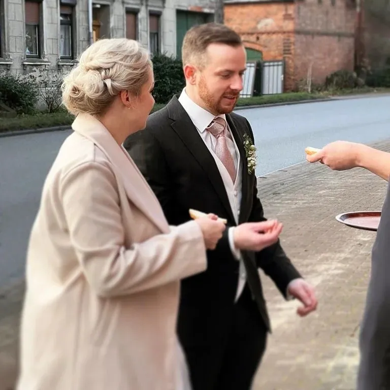 Brautpaar beim Sektempfang vor einem historischen Gebäude