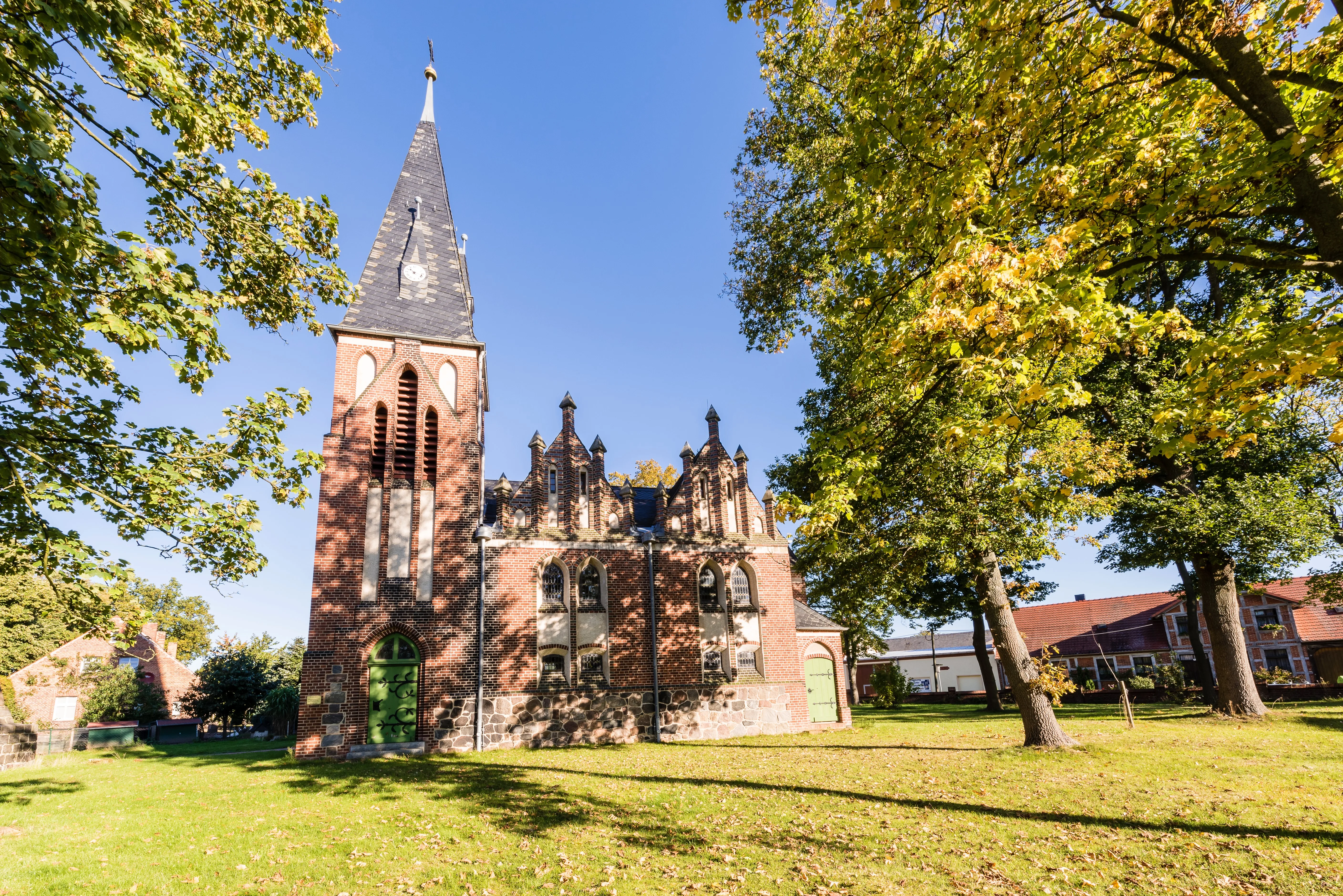 Historische Backsteinkirche in Glövzin unter alten Bäumen